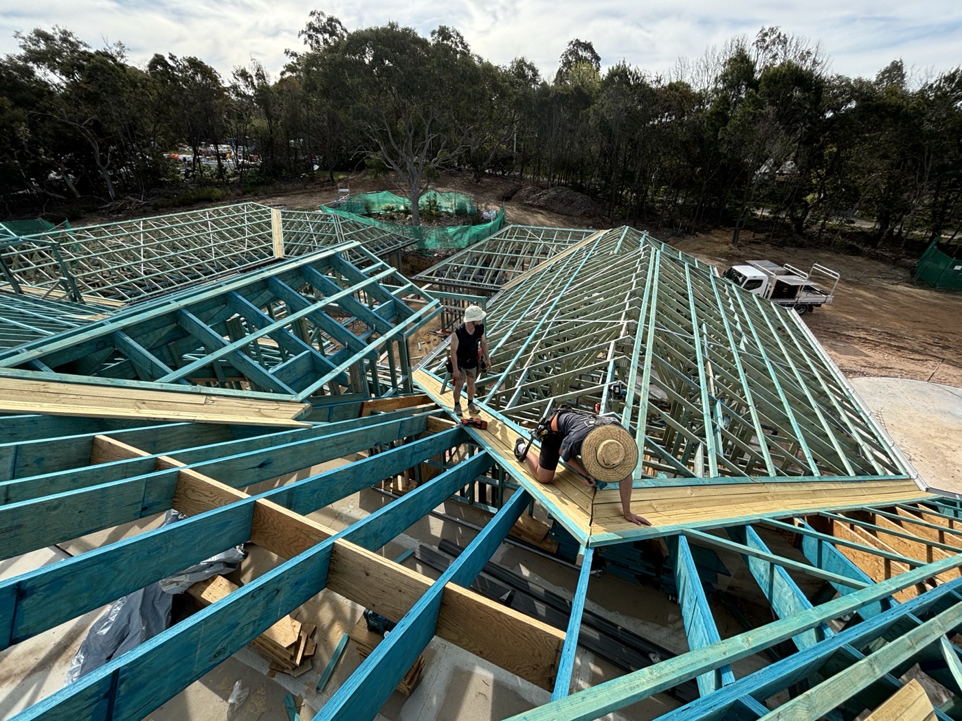 Carpenters working across roof trusses