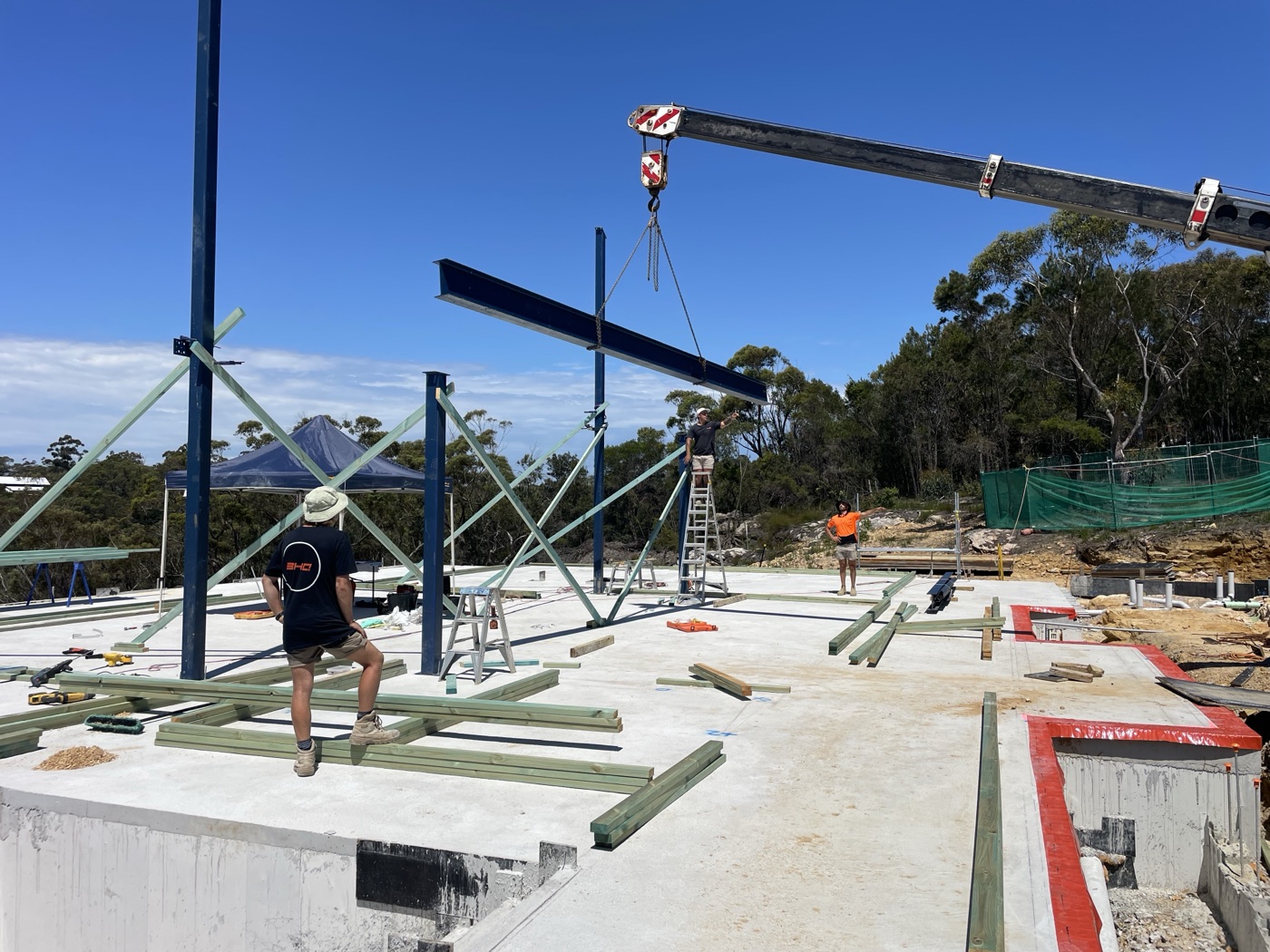 Crew lifting a structural steel beam into place