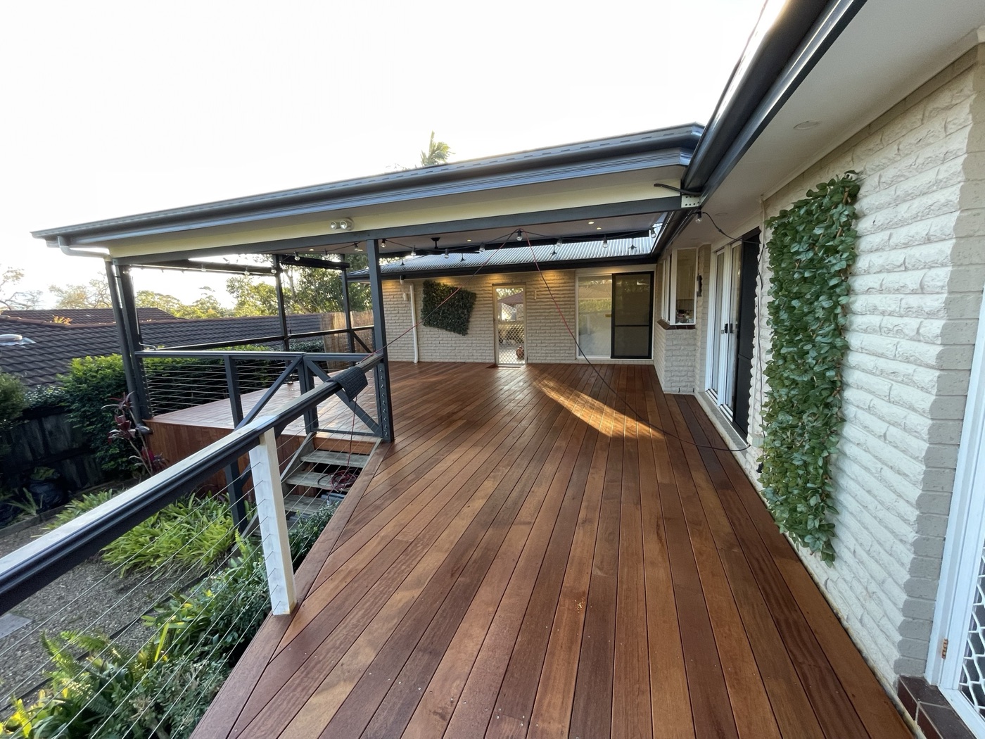 Covered deck alongside brick home