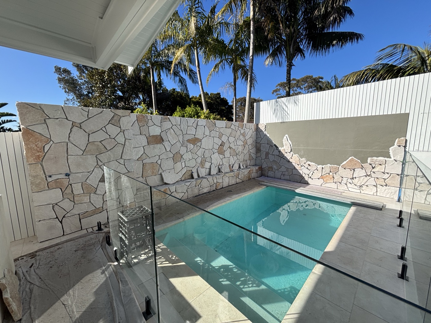 Pool surround with natural stone feature wall